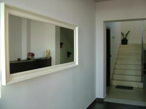 a mirror on a wall in a room with stairs at Sugar and Almond in Agios Stefanos