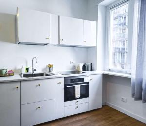 a kitchen with white cabinets and a sink and a window at Morgagni Suites in Bologna +26 photos