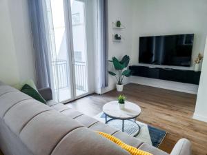 a living room with a couch and a tv at Morgagni Suites in Bologna