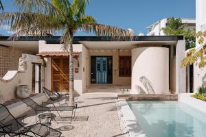 a villa with a swimming pool and a palm tree at Casa Mineli in Campeche