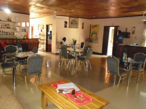 a restaurant with tables and chairs and a person in the background at Wli Water Heights Hotel in Wli Afegame