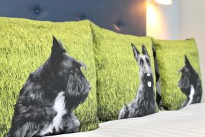 three dogs are sitting on pillows on a bed at Residences at The Gyle - London in London