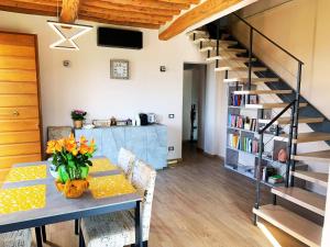 a dining room with a table with flowers on it at Casale SoleLuna - Bagno condiviso in Sorrezzana