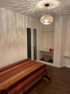 a bedroom with a bed and a chandelier at Villa Al Mar in Caleta de Interián