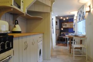 a kitchen with a stove and a dishwasher at Courtyard Cottages Lymington, 2 Adults only in Lymington