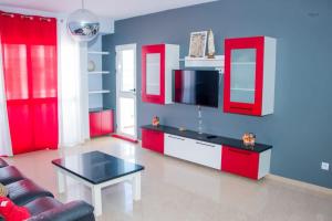 a living room with red cabinets and a tv at Morabeza & Mar in Porto Novo