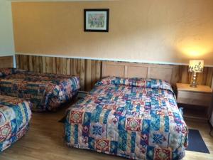 a hotel room with two beds and a table at Carleton Motel and Coffee Shop in Borden-Carleton