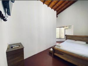 a bedroom with a bed and a dresser in it at Hotel Villa Sara in Doradal