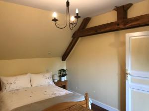 una camera da letto con un letto e un lampadario di Willow Cottage a Saint-Hilaire-sur-Bénaize