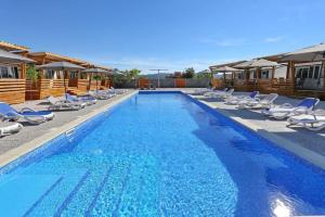 a large swimming pool with lounge chairs at Mobillehome Camp Turanj in Turanj +10 photos