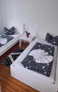 2 Betten in einem Zimmer mit 2 Tischen in der Unterkunft Möblierte 3-Zimmer-Wohnung im Herz von Schwandorf! in Schwandorf in Bayern