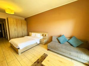 een slaapkamer met 2 bedden en een bank bij Apartment Aldau in Hurghada +21 foto's