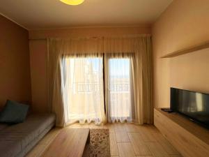een woonkamer met een bank en een groot raam bij Apartment Aldau in Hurghada