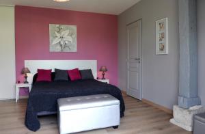 1 dormitorio con cama y pared roja en Le Manège, en Créney-près-Troyes