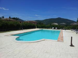 a swimming pool with blue water in a yard at Il Moro Country House in Sant'Orfeto