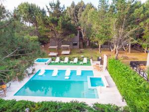 an overhead view of a swimming pool with chairs and a house at PRANAMAR, apart del bosque in Santa Teresita