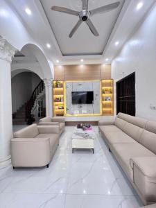a living room with white furniture and a ceiling fan at Ninh Binh Cozy Homestay in Ninh Binh