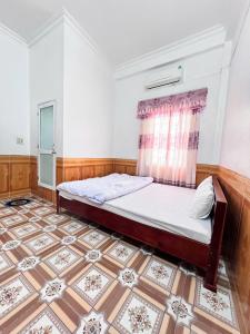 a bedroom with a bed and a tiled floor at Ninh Binh Cozy Homestay in Ninh Binh