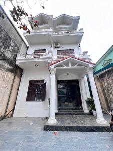 a white building with columns and a entrance at Ninh Binh Cozy Homestay in Ninh Binh +24 photos