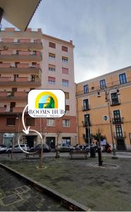 a large building with a sign in front of it at Rooms hub Portarotese in Salerno