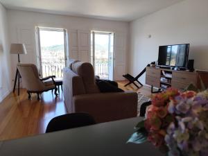 a living room with couches and a flat screen tv at Alma Da Vila in Ponte de Lima