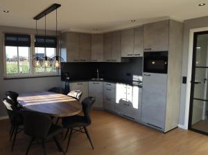 a kitchen with a wooden table and a dining room at NIEUW Landzicht in Serooskerke +28 photos