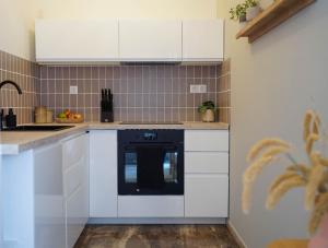 una cucina con armadietti bianchi e lavastoviglie nera di Lefkada City Escape a Città di Lefkada Altre 12 foto