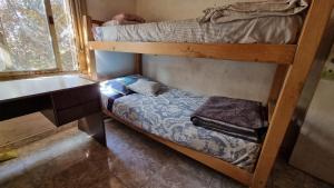 Habitación pequeña con 2 literas y escritorio. en Hostal, La Casa del Patio, en Bahía Blanca