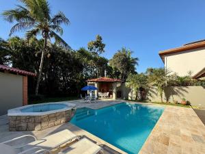 une piscine dans l'arrière-cour d'une maison dans l'établissement Casa 10 Pessoas Riviera de São Lourenço, à Bertioga