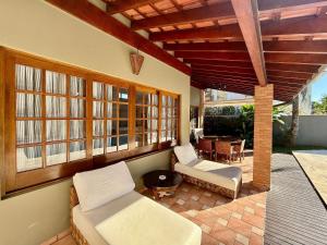 une véranda avec deux canapés et une table dans l'établissement Casa 10 Pessoas Riviera de São Lourenço, à Bertioga