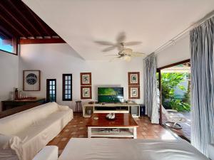 un salon avec un canapé et une télévision dans l'établissement Casa 10 Pessoas Riviera de São Lourenço, à Bertioga