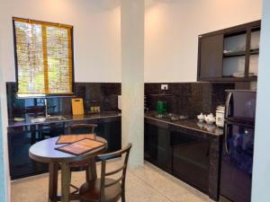 a kitchen with a table and a small table and chairs at The Rail Villa Unawatuna in Talpe