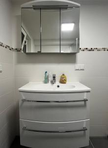 a bathroom with a white sink and a mirror at Frisch Renovierte Souterrain Wohnung in Rodenbach