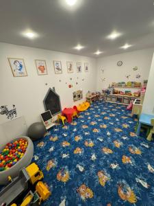 Zimmer mit einem Spielzimmer mit blauem Teppich in der Unterkunft Natura Resort Rozewska in Jastrzębia Góra