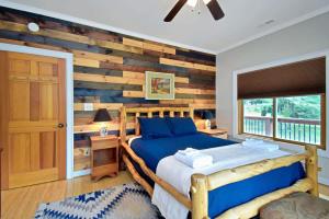 a bedroom with a wooden accent wall and a bed at Boone Mountain Getaway- Hot Tub Firepit in Boone +74 photos
