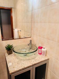 a bathroom with a sink with a glass bowl at 2 Bedroom City Center Haven! in Swakopmund +12 photos