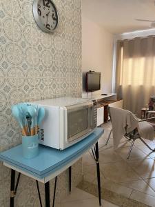 eine Mikrowelle auf einem Tisch mit Küchenutensilien in der Unterkunft Aguas de Lindoia pertinho de tudo in Águas de Lindóia