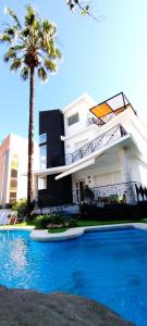 un edificio con una palmera y una piscina en Villa Dorada Beach Alicante, en Alicante