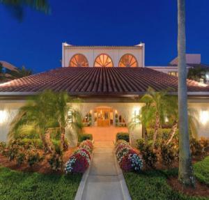 a large white house with a balcony and trees at Wyndham Boca Raton Hotel in Boca Raton