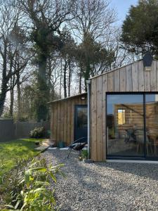 a small wooden house with a large window at La Cabane in Quiberville