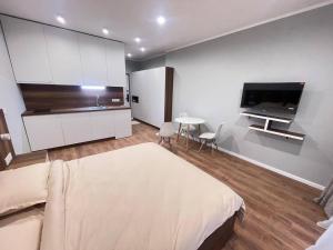 a bedroom with a bed and a tv and a table at Sunny Spot Batumi in Batumi