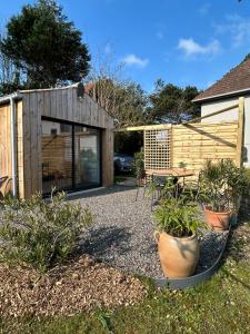 a garden with potted plants in front of a building at La Cabane in Quiberville +11 photos