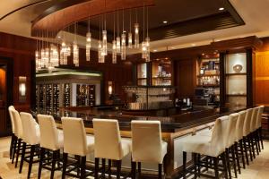 a bar in a restaurant with white chairs at Caesars Windsor Hotel and Casino in Windsor