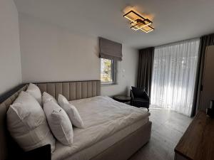 een slaapkamer met een bed, een stoel en een raam bij Sandapartments East Beach in Rowy +22 foto's