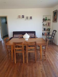 une table de salle à manger avec des chaises et un vase dessus dans l'établissement GITE chez mamie - 7 personnes A SAINTE LIVRADE SUR LOT, à Sainte-Livrade-sur-Lot