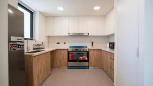 a kitchen with white cabinets and a stove at 4br Spacious Villa Backyard in Abu Dhabi