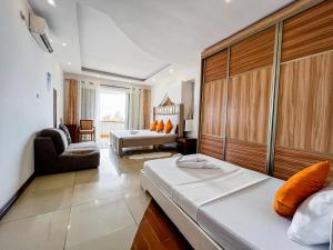 a hotel room with two beds and a living room at Serene Sea View One Bedroom Apt Shanzu in Mombasa
