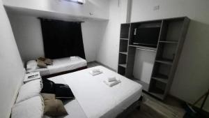 een kleine kamer met een bank en een tv bij Solano House in Termas de Río Hondo