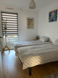 a bedroom with a bed and a window at Appartement cosy jardin des plantes avec parking in Nantes