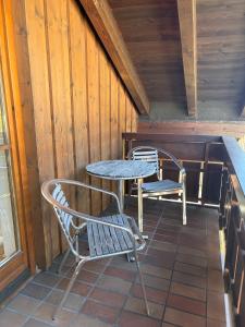 a patio with two chairs and a table on a porch at Neu! Alpenapartment Moritz, Balkon, Tiefgarage in Rettenberg